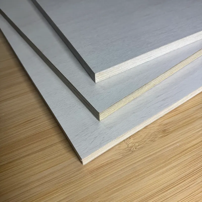 Light grey laminated plywood panels stacked on a bamboo surface